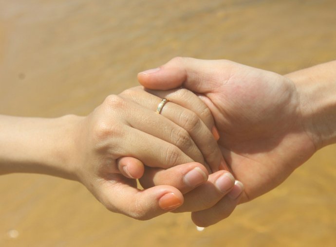 Two hands gently clasped together in support